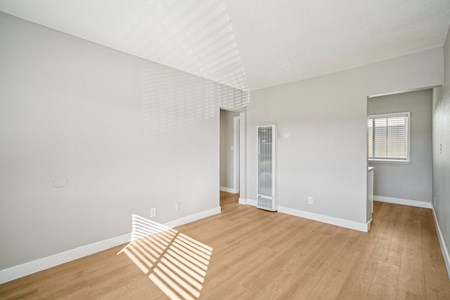 A room with a white ceiling and wooden flooring.